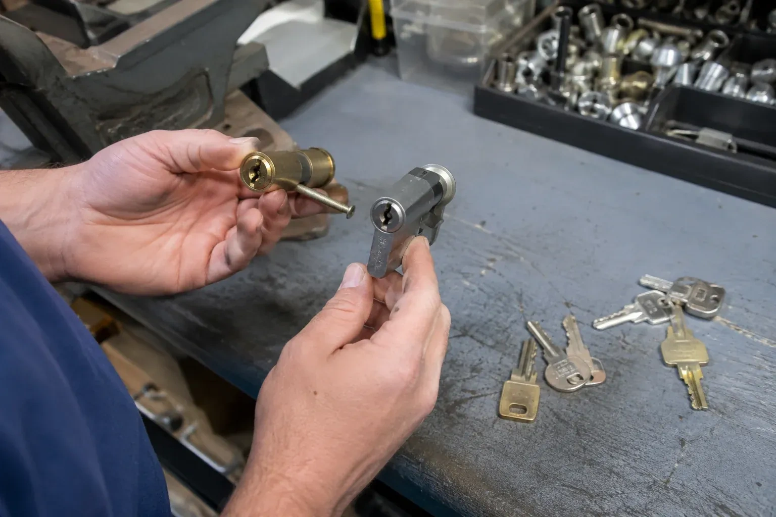 Hands comparing detached lock cylinders beside loose keys on a workbench. — Broken Key Extraction, Richmond Hill